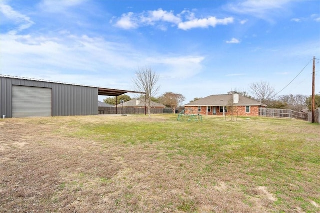 view of yard featuring fence, a playground, and an outbuilding