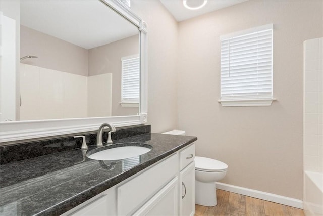 full bath with baseboards, vanity, toilet, and wood finished floors