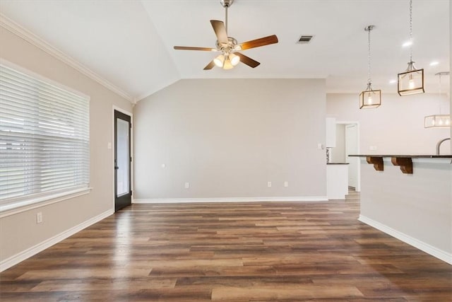 spare room featuring lofted ceiling, ceiling fan, visible vents, baseboards, and dark wood finished floors