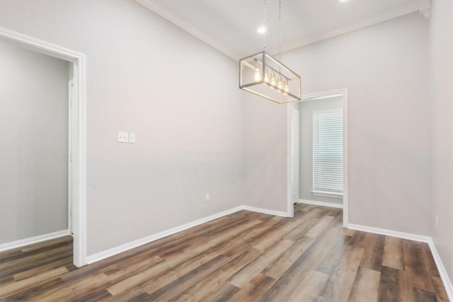 unfurnished dining area featuring ornamental molding, baseboards, and wood finished floors