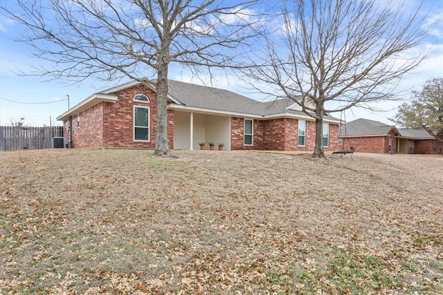 single story home with brick siding, fence, and central AC unit