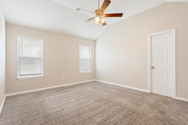 carpeted spare room with lofted ceiling, a ceiling fan, and baseboards