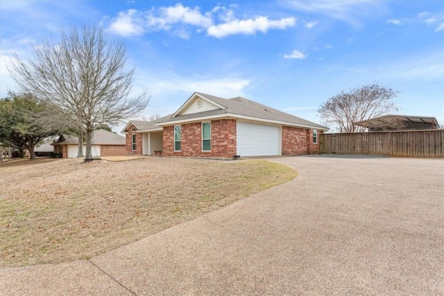 ranch-style house featuring aphalt driveway, brick siding, fence, and an attached garage