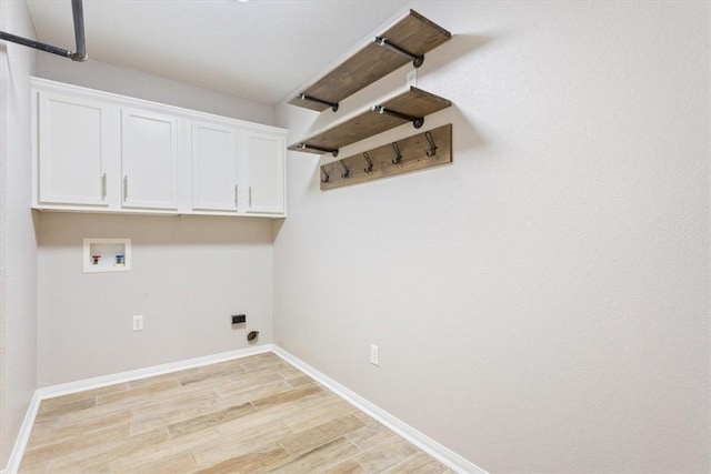 washroom with cabinet space, light wood finished floors, baseboards, hookup for an electric dryer, and washer hookup