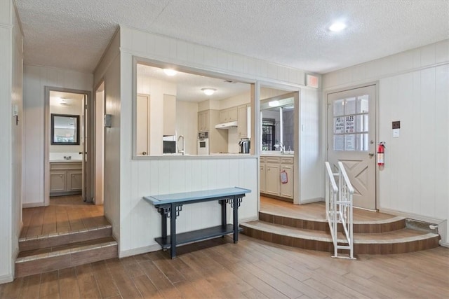 interior space with hardwood / wood-style flooring, sink, and a textured ceiling