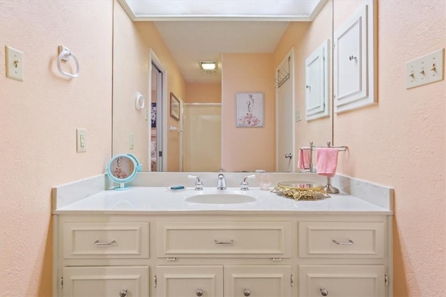 bathroom with vanity and a shower