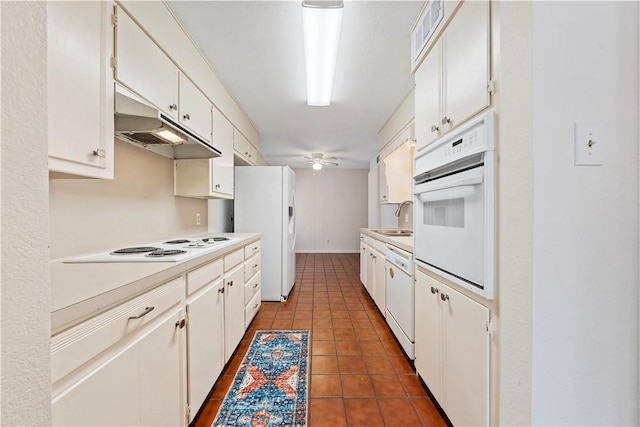 kitchen with tile patterned flooring, white cabinetry, white appliances, and sink