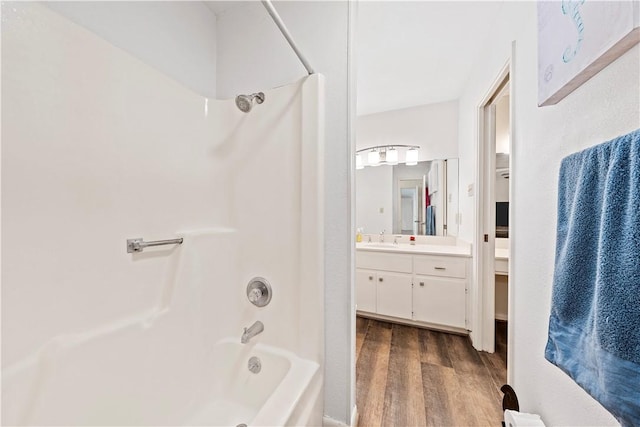 bathroom with hardwood / wood-style floors, vanity, and shower / bathtub combination