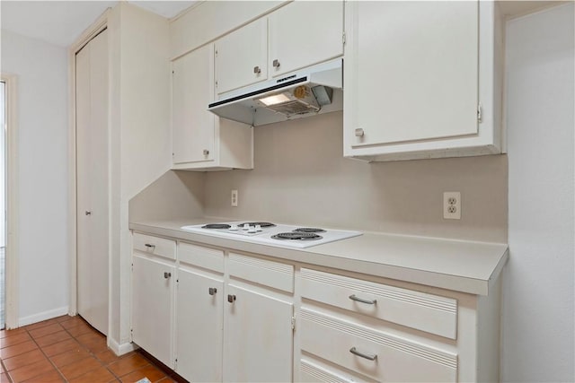 kitchen with white electric stovetop, white cabinetry, and light tile patterned floors