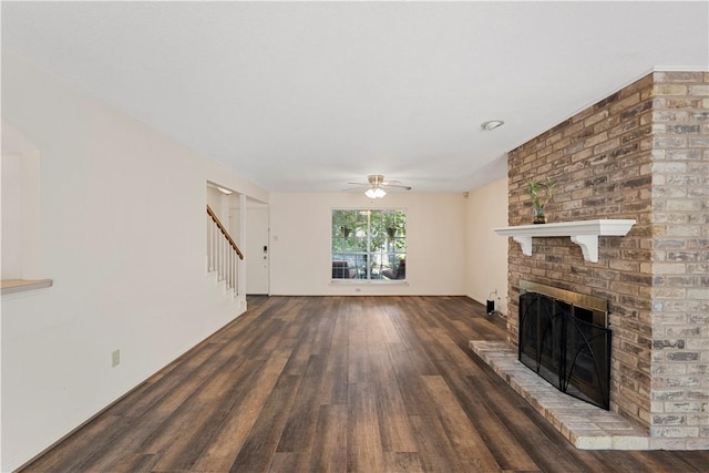 unfurnished living room featuring dark hardwood / wood-style floors, ceiling fan, and a fireplace