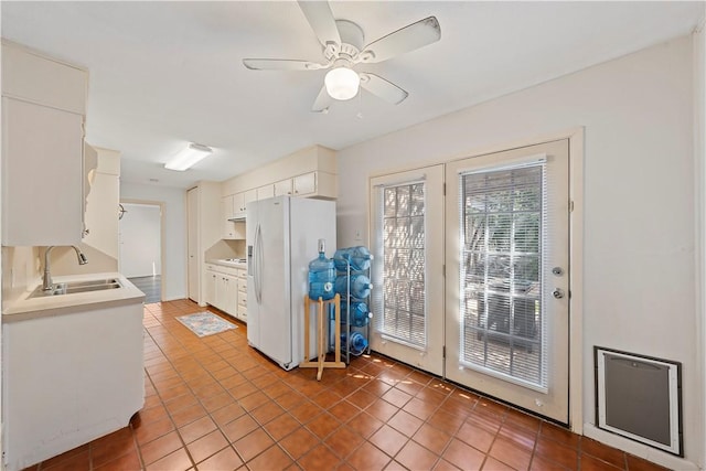 kitchen featuring white cabinets, ceiling fan, sink, white refrigerator with ice dispenser, and tile patterned flooring