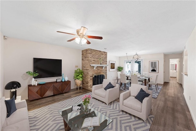 living room with ceiling fan, hardwood / wood-style floors, and a brick fireplace