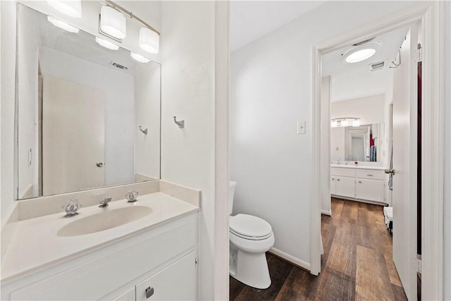 bathroom with vanity, toilet, and wood-type flooring