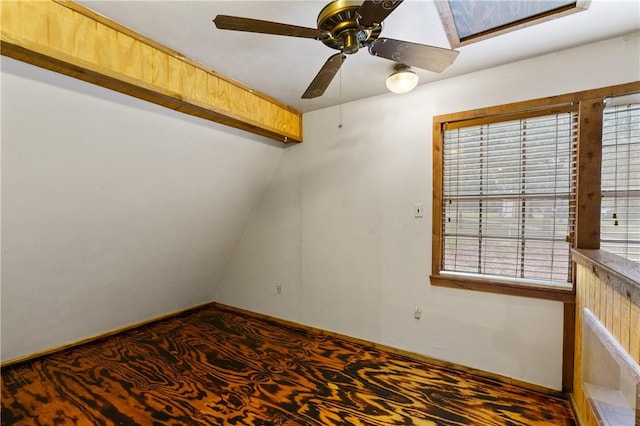 empty room with ceiling fan, a healthy amount of sunlight, and lofted ceiling