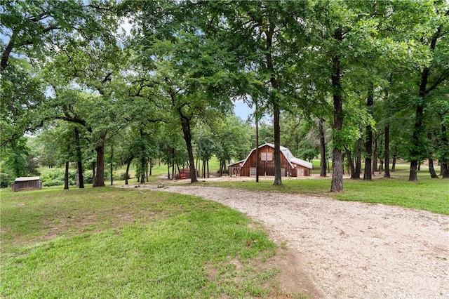 view of community featuring a yard and an outdoor structure