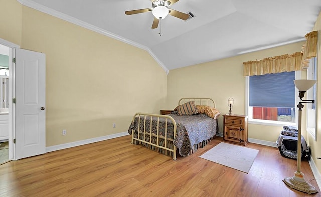 bedroom with lofted ceiling, a ceiling fan, wood finished floors, crown molding, and baseboards