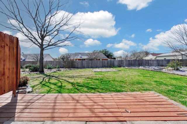 wooden deck featuring a yard and a fenced backyard