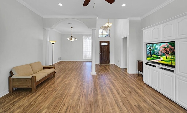 foyer entrance with crown molding, baseboards, decorative columns, ceiling fan with notable chandelier, and light wood-style floors