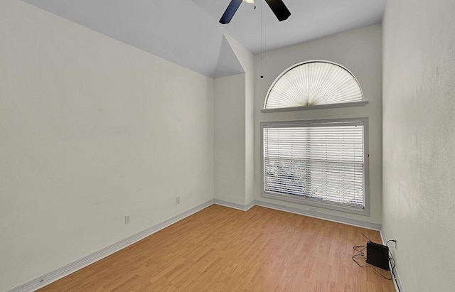 spare room with baseboards, ceiling fan, and wood finished floors