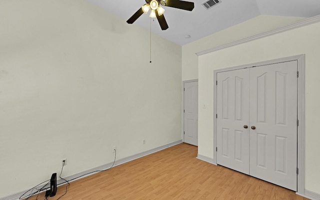 unfurnished bedroom featuring visible vents, ceiling fan, baseboards, light wood-type flooring, and lofted ceiling