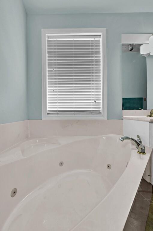 full bath featuring a tub with jets and tile patterned flooring