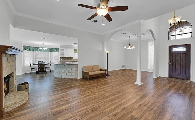 entrance foyer with visible vents, ornamental molding, dark wood-style floors, arched walkways, and decorative columns