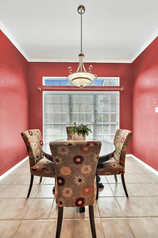 tiled dining space featuring ornamental molding