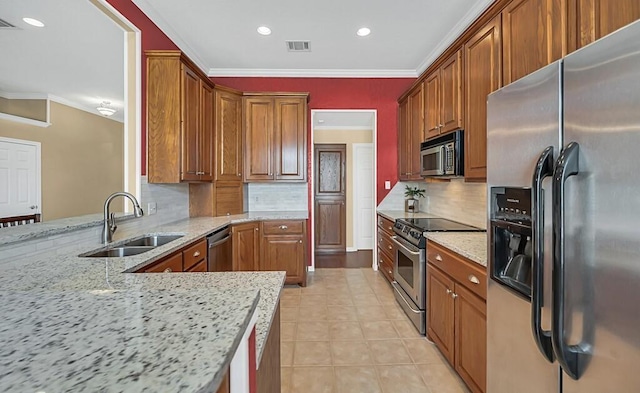 kitchen featuring light stone countertops, appliances with stainless steel finishes, backsplash, crown molding, and sink