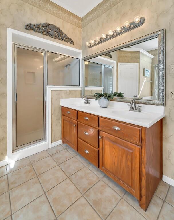 bathroom featuring tile patterned floors, vanity, and a shower with shower door