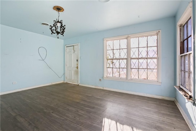 unfurnished room with dark hardwood / wood-style flooring and an inviting chandelier