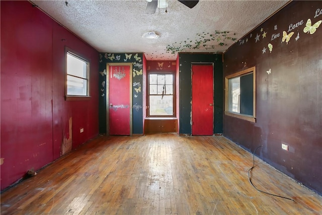 unfurnished room featuring hardwood / wood-style floors, a textured ceiling, and ceiling fan