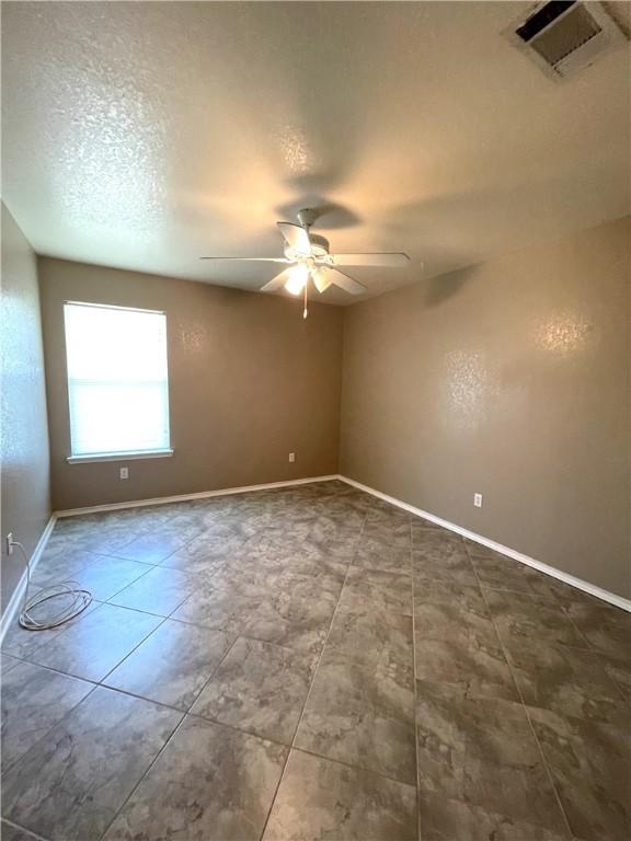 unfurnished room featuring a textured ceiling and ceiling fan