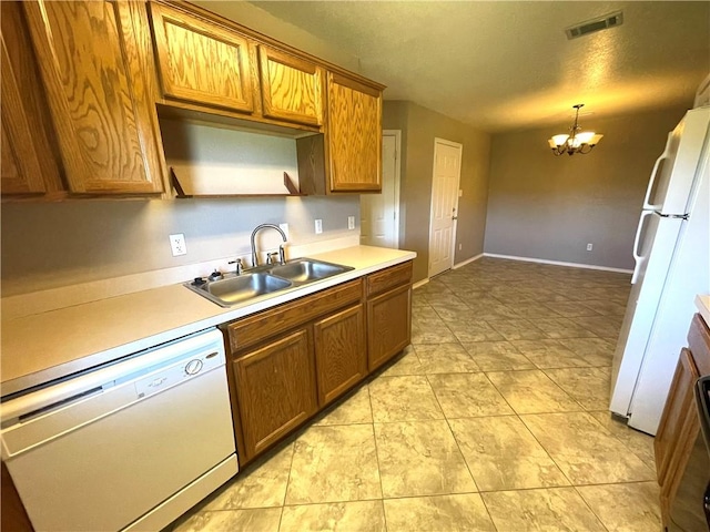 kitchen featuring white appliances, sink, pendant lighting, an inviting chandelier, and light tile patterned flooring