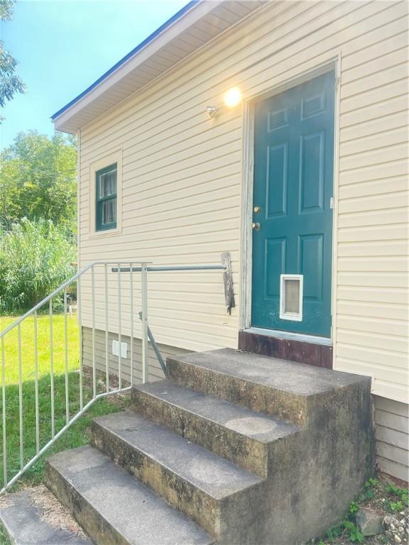 view of exterior entry with a yard