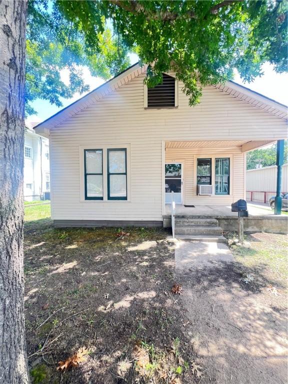 rear view of house featuring covered porch