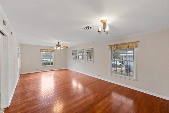 unfurnished room with ceiling fan with notable chandelier, hardwood / wood-style flooring, and crown molding