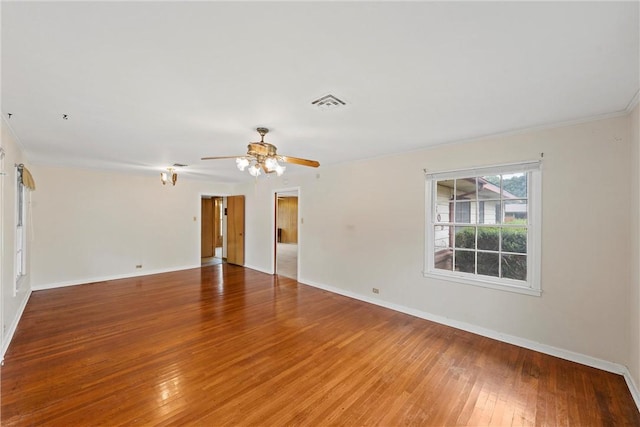 empty room featuring ceiling fan, wood-type flooring, and ornamental molding