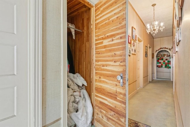 corridor with wooden walls and a chandelier