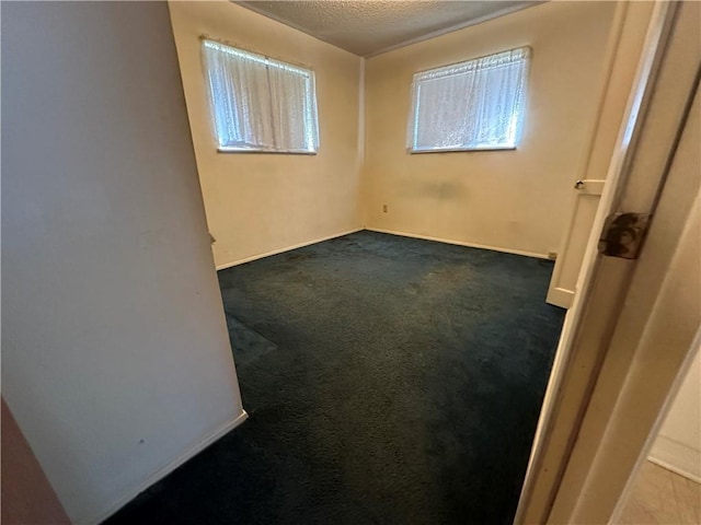 carpeted empty room with a textured ceiling