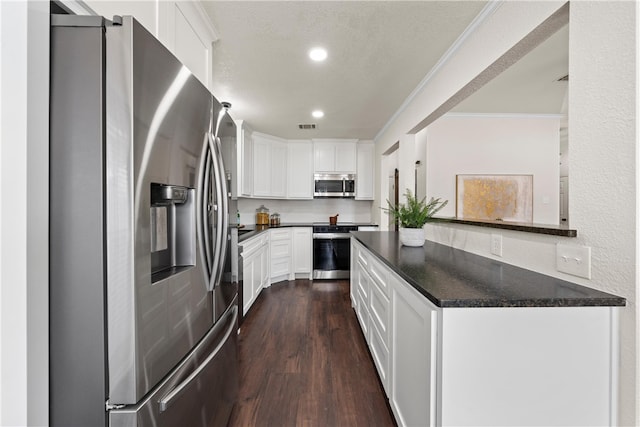 kitchen with crown molding, appliances with stainless steel finishes, white cabinetry, kitchen peninsula, and dark wood-type flooring