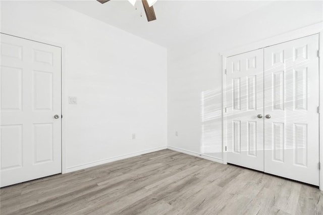 unfurnished bedroom with ceiling fan, light wood-type flooring, and a closet