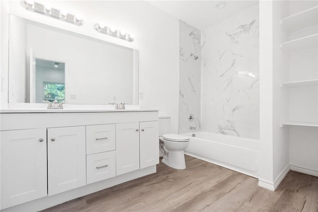 full bathroom featuring vanity, wood-type flooring, tiled shower / bath combo, and toilet