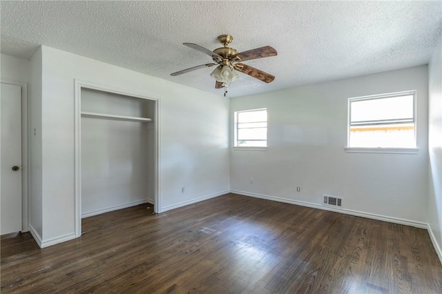 unfurnished bedroom with ceiling fan, dark wood-type flooring, and a textured ceiling