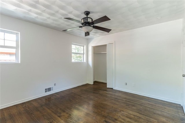 unfurnished bedroom featuring a closet, ceiling fan, and dark hardwood / wood-style flooring