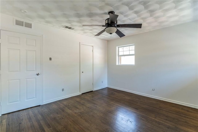 unfurnished bedroom with dark hardwood / wood-style flooring and ceiling fan