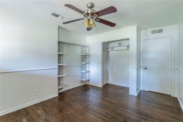 unfurnished bedroom with a textured ceiling, ceiling fan, dark wood-type flooring, and a closet