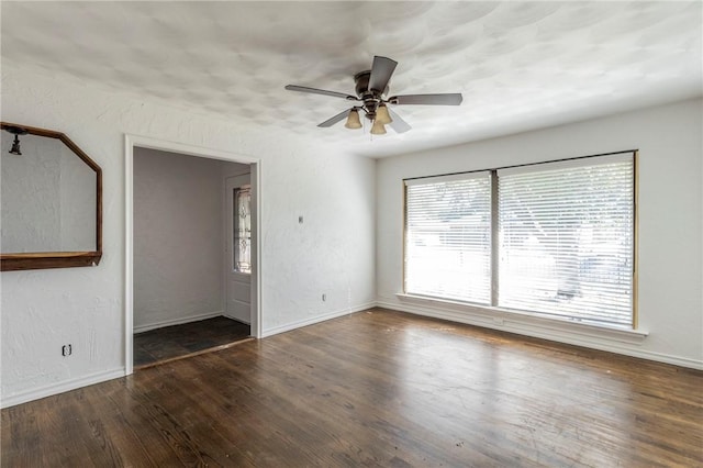 unfurnished room with ceiling fan and dark wood-type flooring