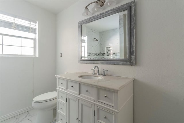 bathroom with vanity, toilet, and tiled shower