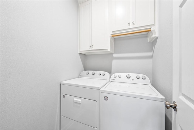 laundry area with washing machine and dryer and cabinets