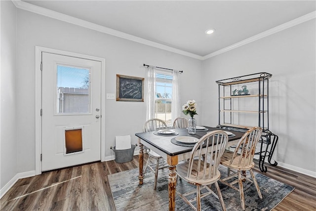 dining area with ornamental molding and dark hardwood / wood-style floors